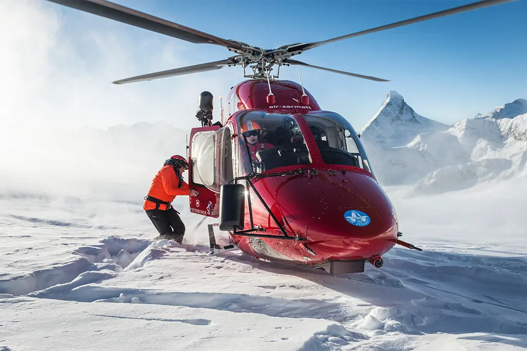 Helikopter im verschneiten Gebirge bei einem exklusiven Winterevent von team projekt, außergewöhnliches Firmenincentive mit Schneeschuhwandern und alpinem Erlebnis