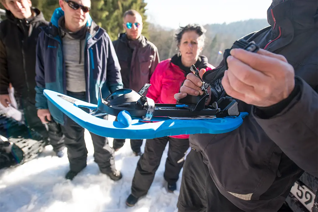 Teilnehmergruppe eines Winter-Incentives bei der Einweisung in den Umgang mit Schneeschuhen im Rahmen eines Schneeschuh-Workshops
