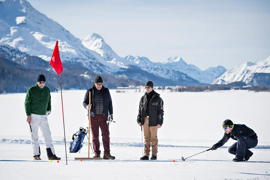 Teilnehmer beim Eisgolf vor alpiner Bergkulisse, exklusives Winterevent von team projekt als Firmen Incentive und außergewöhnliches Teambuilding Programm