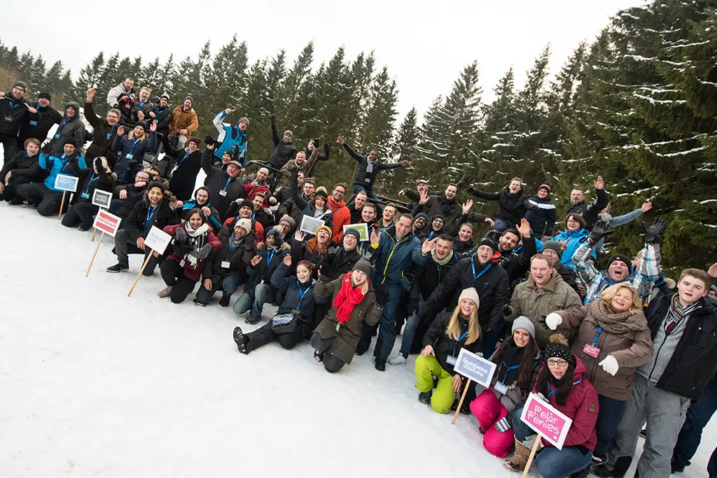 Große Gruppe von Teilnehmern bei einem Schneeschuh Firmen Event von team projekt, gemeinsames Winterincentive im Schnee mit Teambuilding Charakter