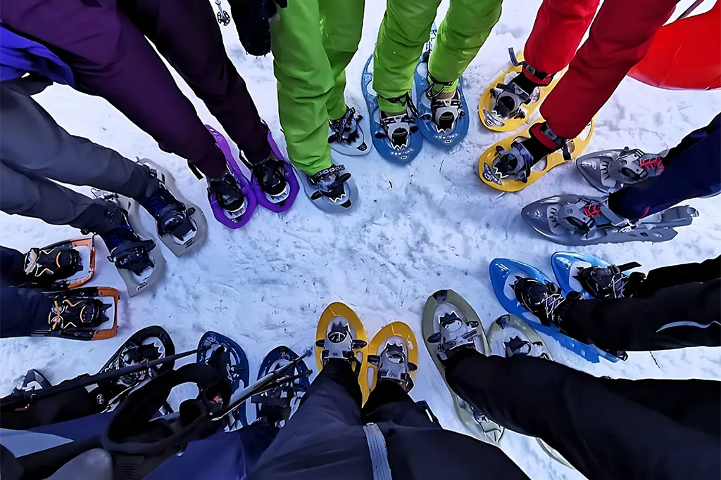 Große Eventgruppe mit vielen Schneeschuhen bei einem Firmen-Schneeschuhevent am Schluchsee im Schwarzwald. Bei der Schneeschuhtour handelt es sich um Teilnehmer eines Livemarketing-Winterevents.