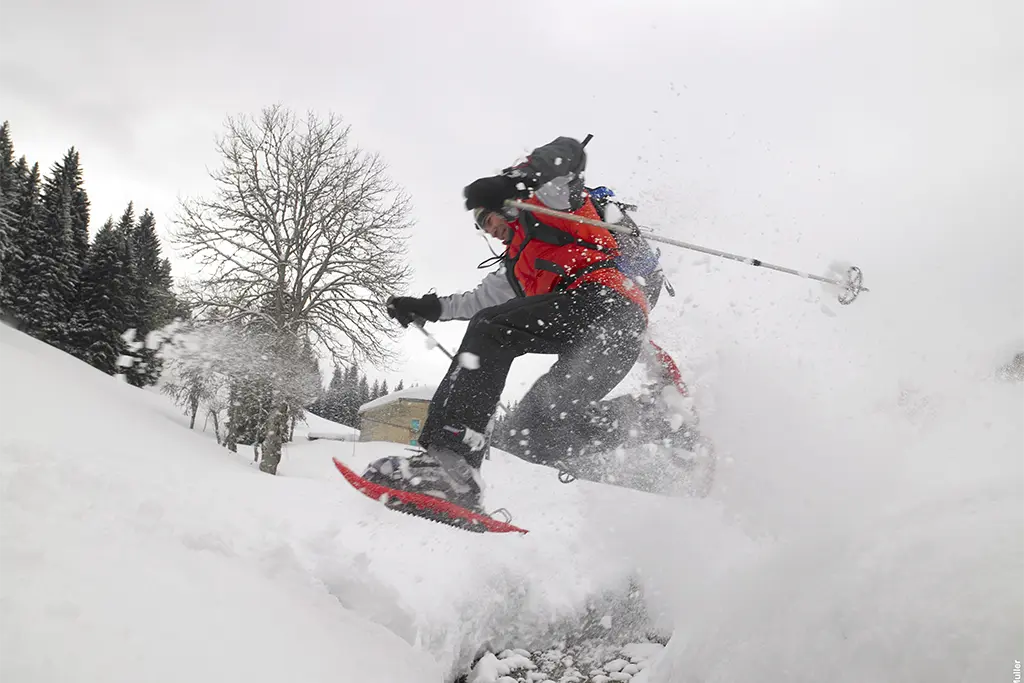Sprung im Tiefschnee mit Schneeschuhen bei einer actionreichen Winter Challenge in Géradmer (Vogesen bzw. Elsass). Das Foto wurde bei einem Teamevent im Schnee mit der deutschsprachigen elsässer Eventagentur team projekt erstellt.