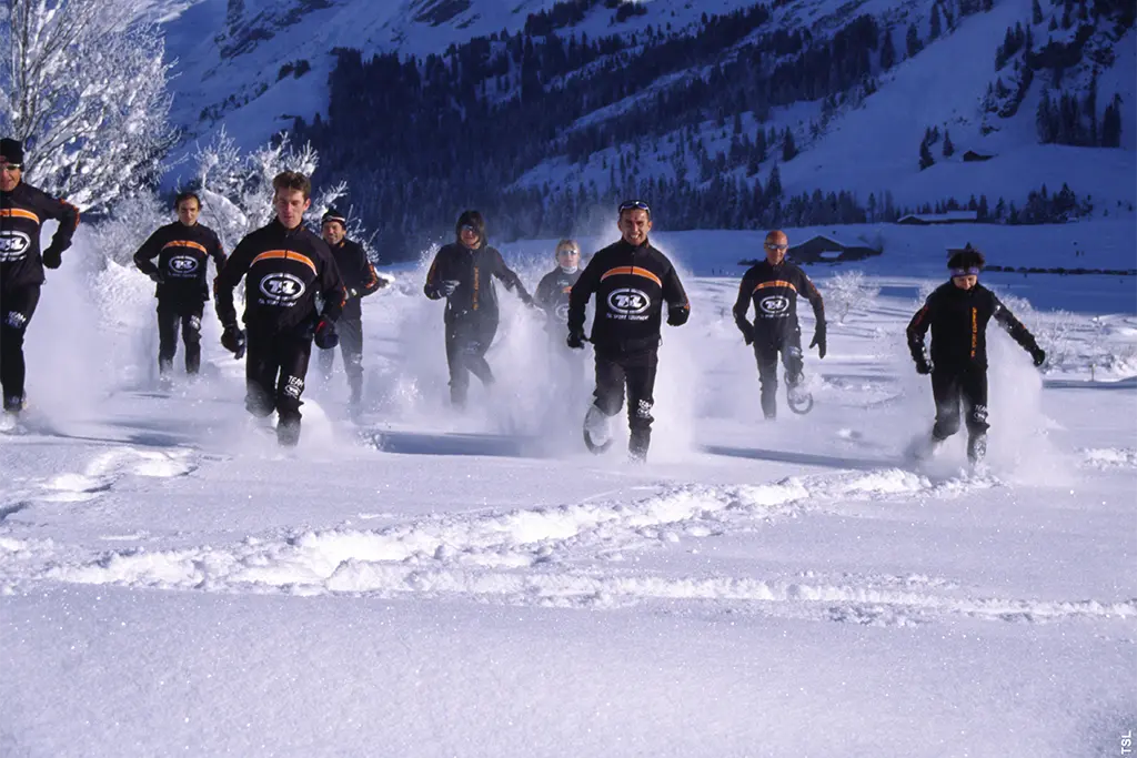 Gruppe von Sportlern bei einer Schneeschuh Challenge im Tiefschnee, actionreiches Winterevent von team projekt für Firmen mit Incentive und Teambuilding Charakter