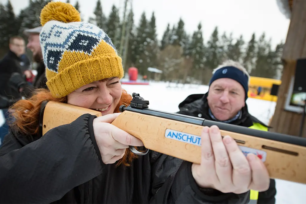 Eine Teilnehmerin schießt mit einem Laserbiathlongewehr auf einer mobilen Laserschießanlage des  Event Veranstalter team projekt am Titisee im Schwarzwald