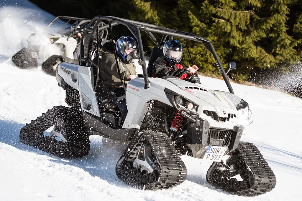 Actionparcours mit zwei Buggys mit Schneeraupen bei einem Driving Event im Schnee mit begeisterten Eventteilnehmern die eine Incentivereise im Winter gewonnen haben