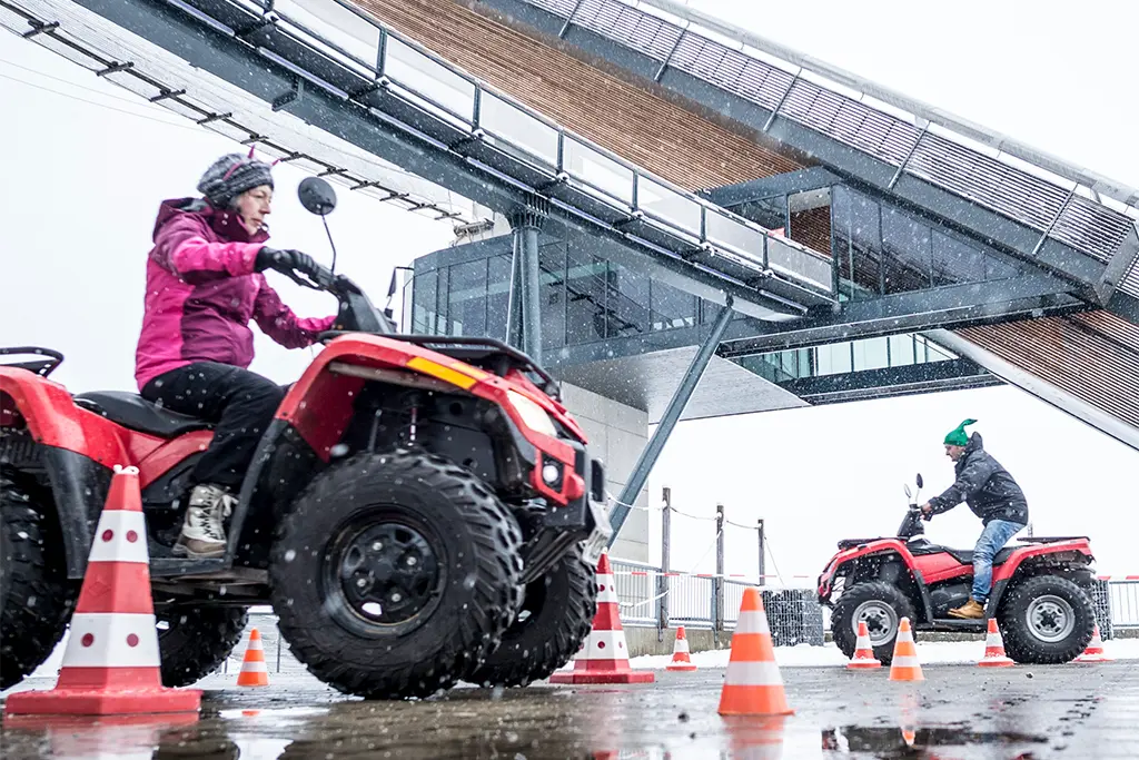 Zwei Teilnehmer auf Quads bei einem Winter-Incentive im Allgäu im Rahmen einer Winterolympiade (Winterteamevent)