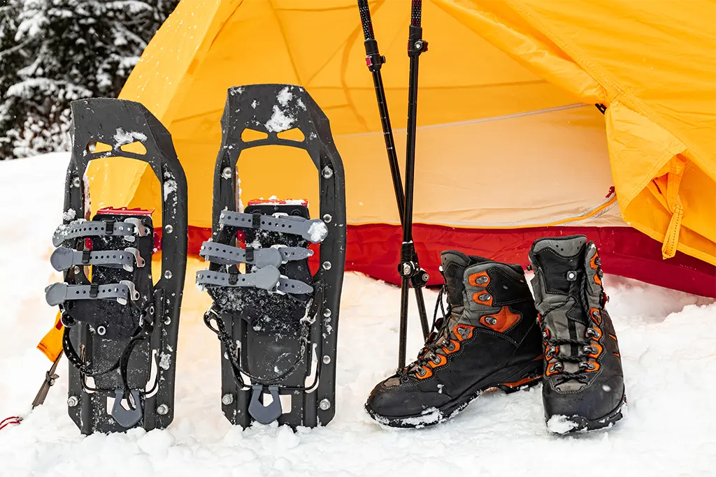 Schneeschuhe vor einem Trekkingzelt im Schnee im Rahmen eines Winter-Teamtrainings bei einem Managertrainings im Schnee